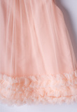 EBITA tulle dress in salmon color with ruffles at the hem.