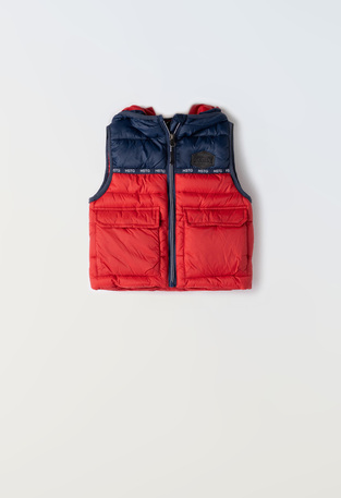 HASHTAG sleeveless jacket in red with a hood.