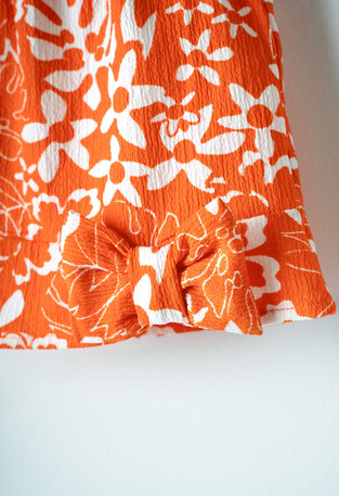 EBITA pants set in orange color with floral print.