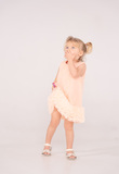 EBITA tulle dress in salmon color with ruffles at the hem.